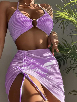 a woman in a purple bikini top and skirt