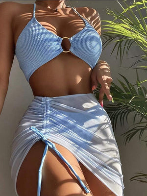 a woman in a blue bikini top and white skirt