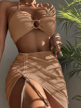 a woman in a tan bikini top and skirt