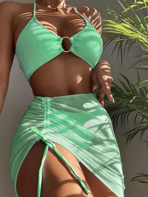 a woman in a green bikini top and skirt