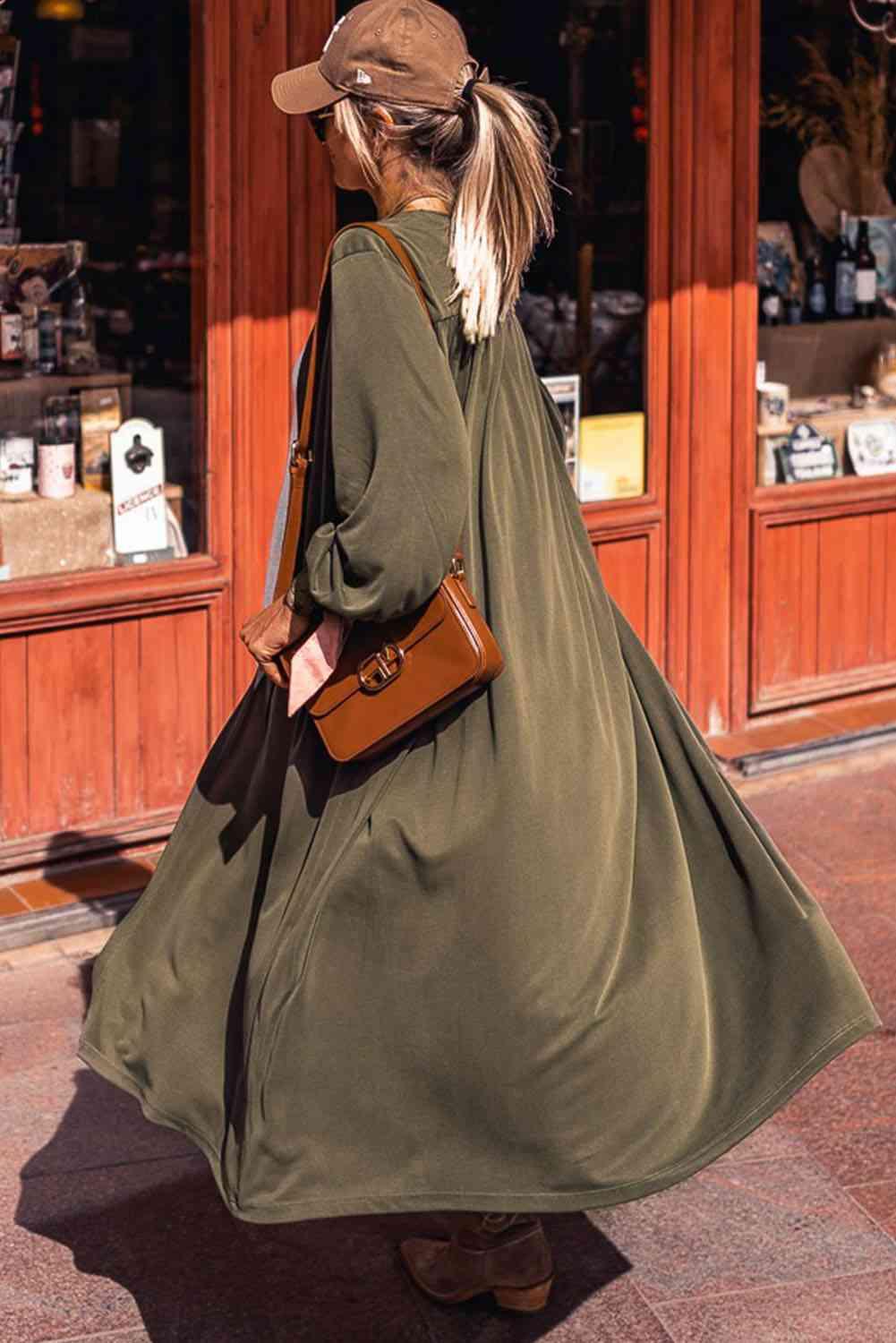 a woman walking down the street carrying a brown purse