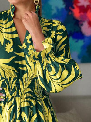 a woman in a green and yellow dress posing for a picture