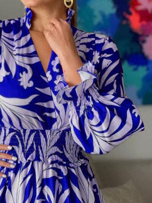 a woman in a blue and white dress posing for a picture