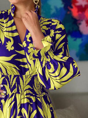 a woman in a blue and yellow dress posing for a picture