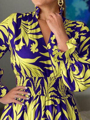 a woman in a blue and yellow dress posing for a picture