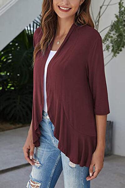 a woman wearing a burgundy top and ripped jeans