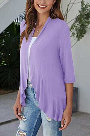 a woman wearing a purple top and ripped jeans