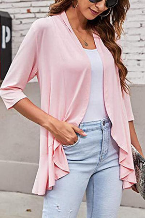 a woman wearing a pink jacket and jeans