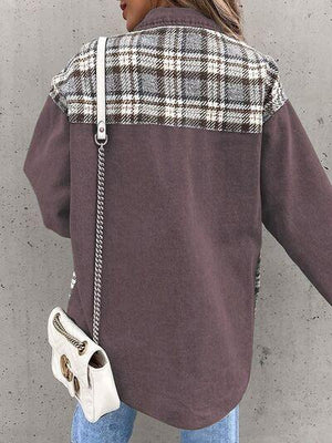 a woman with a handbag standing against a wall