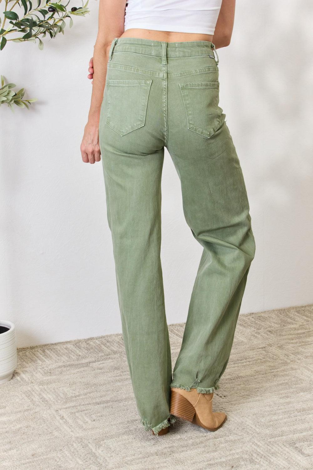 a woman in a white top and green pants