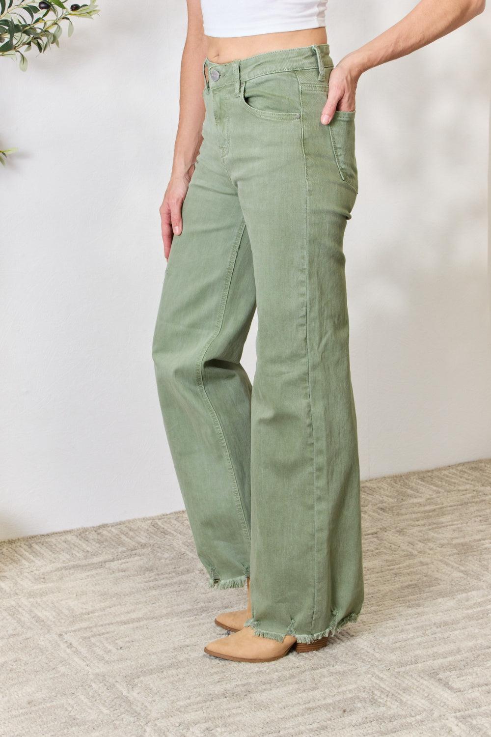 a woman in a white top and green pants