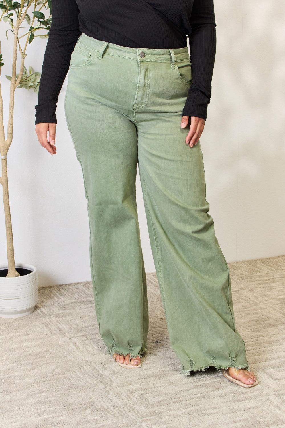 a woman in a black top and green pants