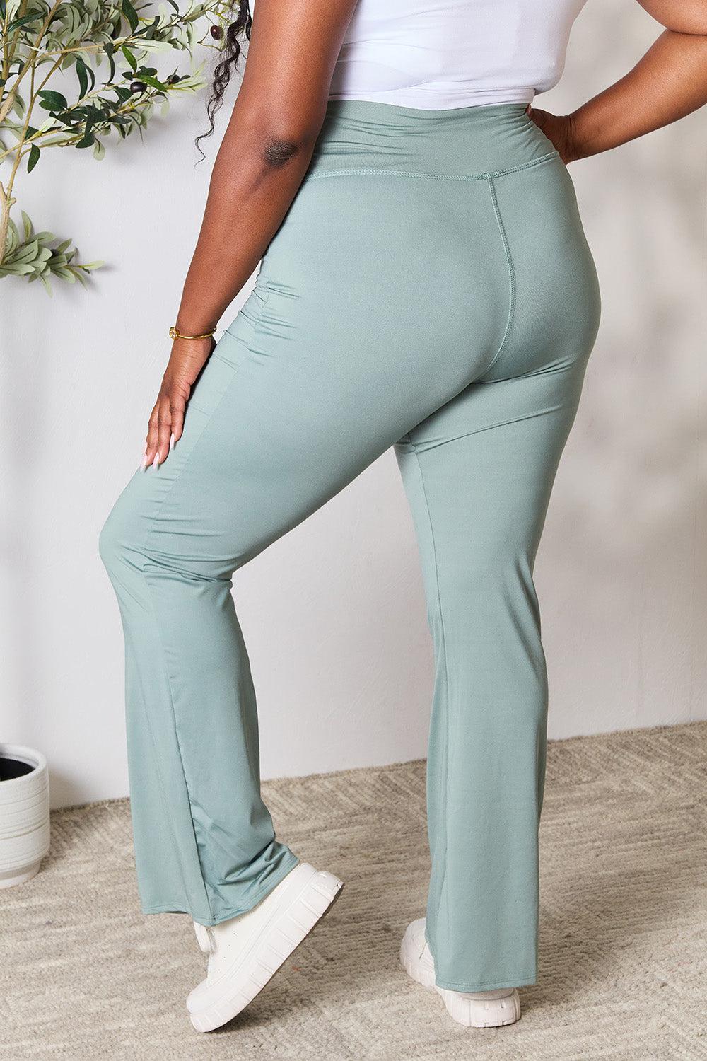 a woman in a white tank top and mint green pants