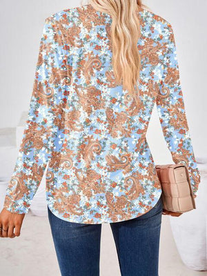 a woman wearing a blue and orange floral shirt