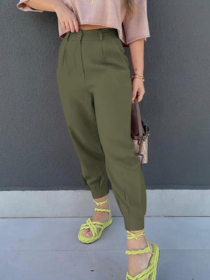 a woman wearing a pink shirt and green pants