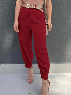a woman wearing red pants and a tan top