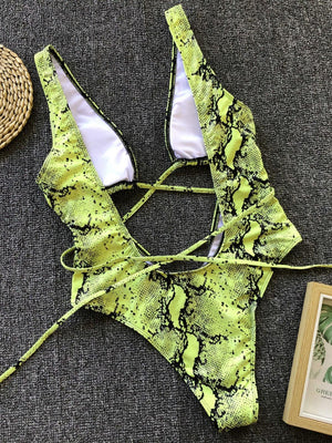 a woman's green and black bikini top next to a straw hat