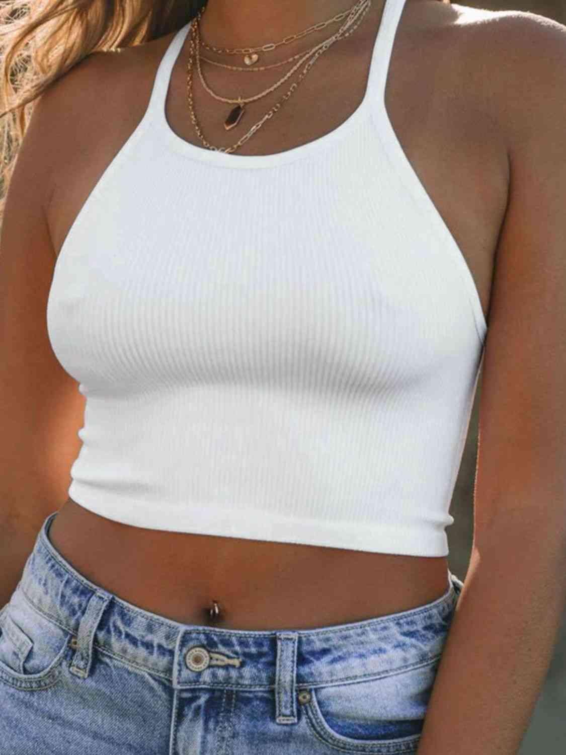 a woman wearing a white crop top and jeans