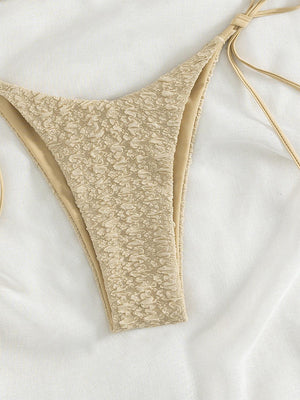 a bikini top and a pair of scissors on a bed