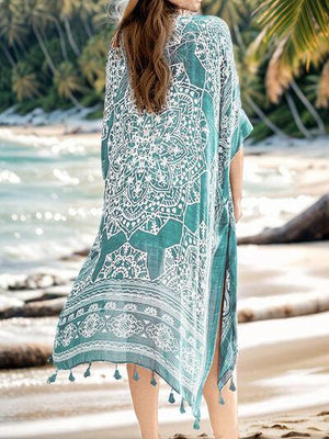 a woman standing on a beach wearing a blue and white cover up