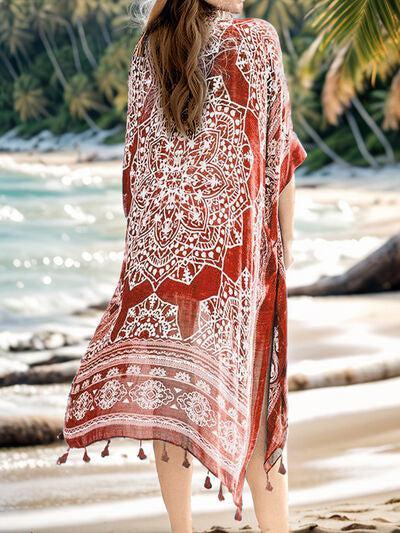 a woman standing on a beach wearing a red and white cover up