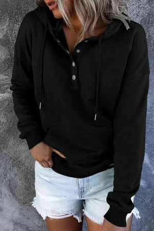 a woman wearing a black hoodie and ripped shorts