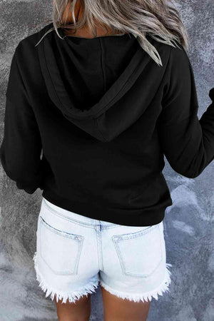 a woman wearing white shorts and a black hoodie