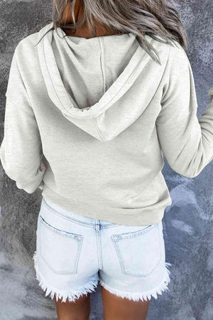 a woman wearing a white hoodie and denim shorts