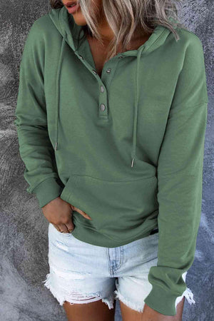 a woman wearing a green hoodie and ripped shorts