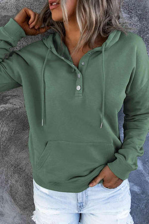 a woman wearing a green hoodie and ripped jeans