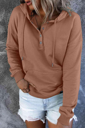 a woman wearing a brown hoodie and ripped shorts