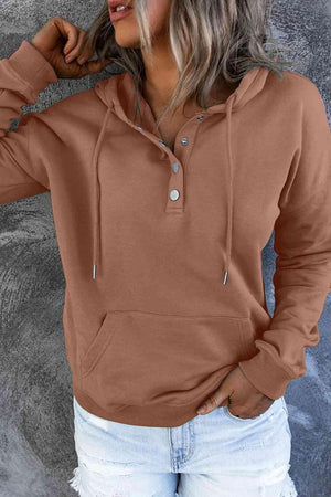a woman wearing a brown hoodie and ripped jeans