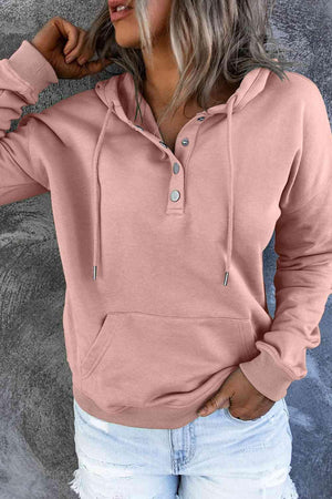 a woman wearing a pink hoodie and ripped jeans