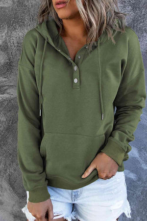 a woman wearing a green hoodie and ripped shorts