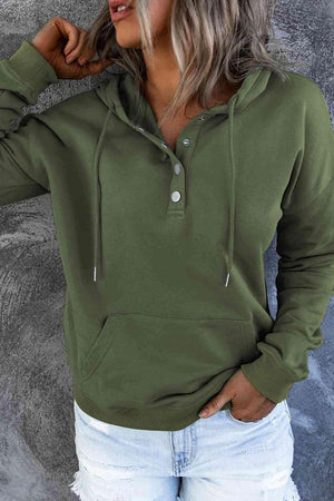 a woman wearing a green hoodie and ripped jeans