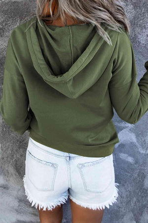 a woman wearing a green hoodie and white shorts