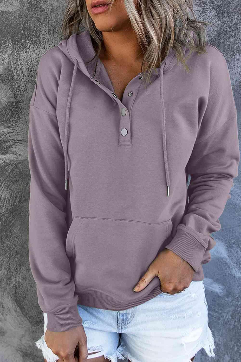 a woman wearing a purple hoodie and ripped shorts