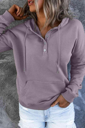 a woman wearing a purple hoodie and ripped jeans