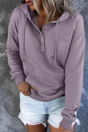 a woman wearing a purple hoodie and ripped shorts