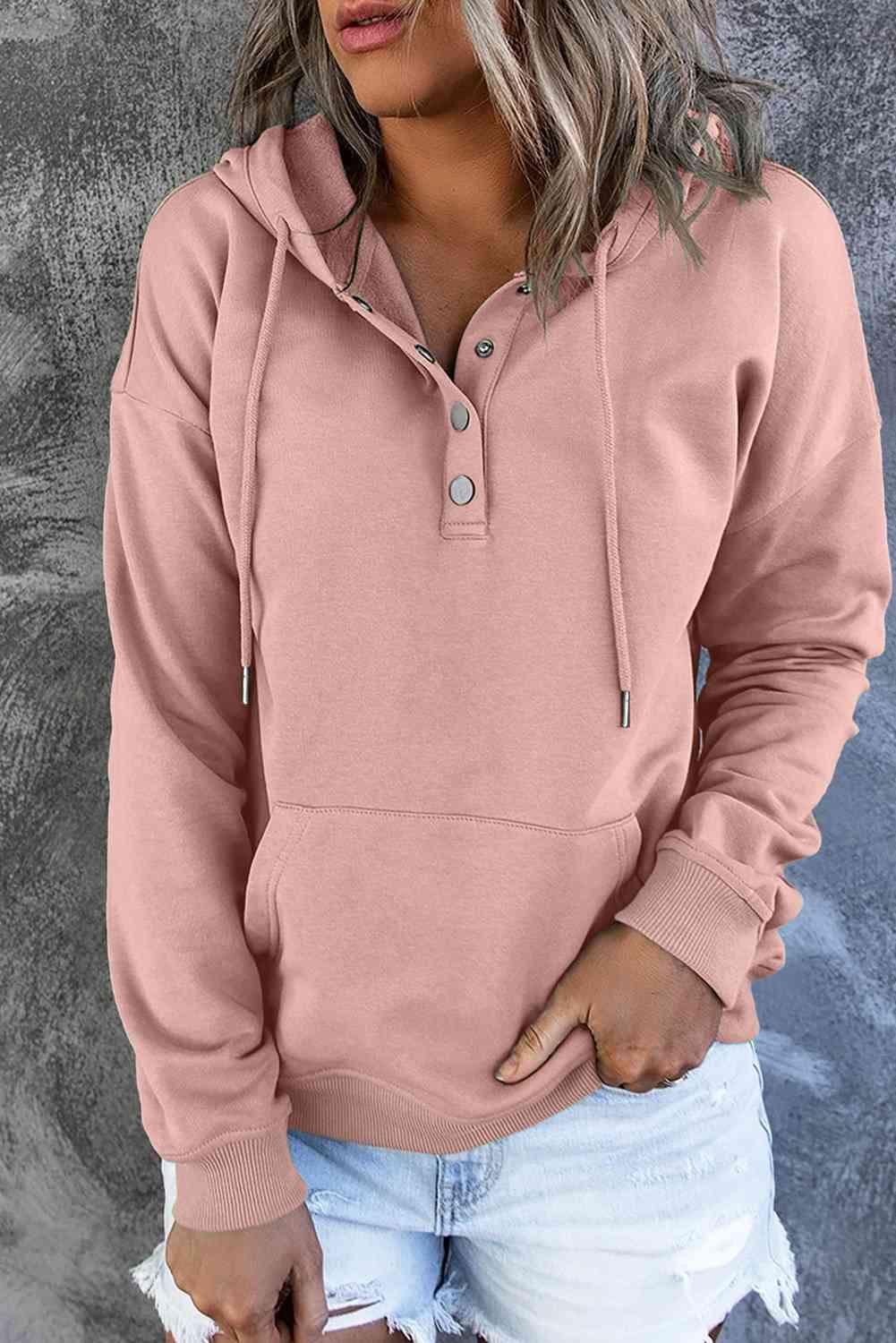 a woman wearing a pink hoodie and ripped shorts