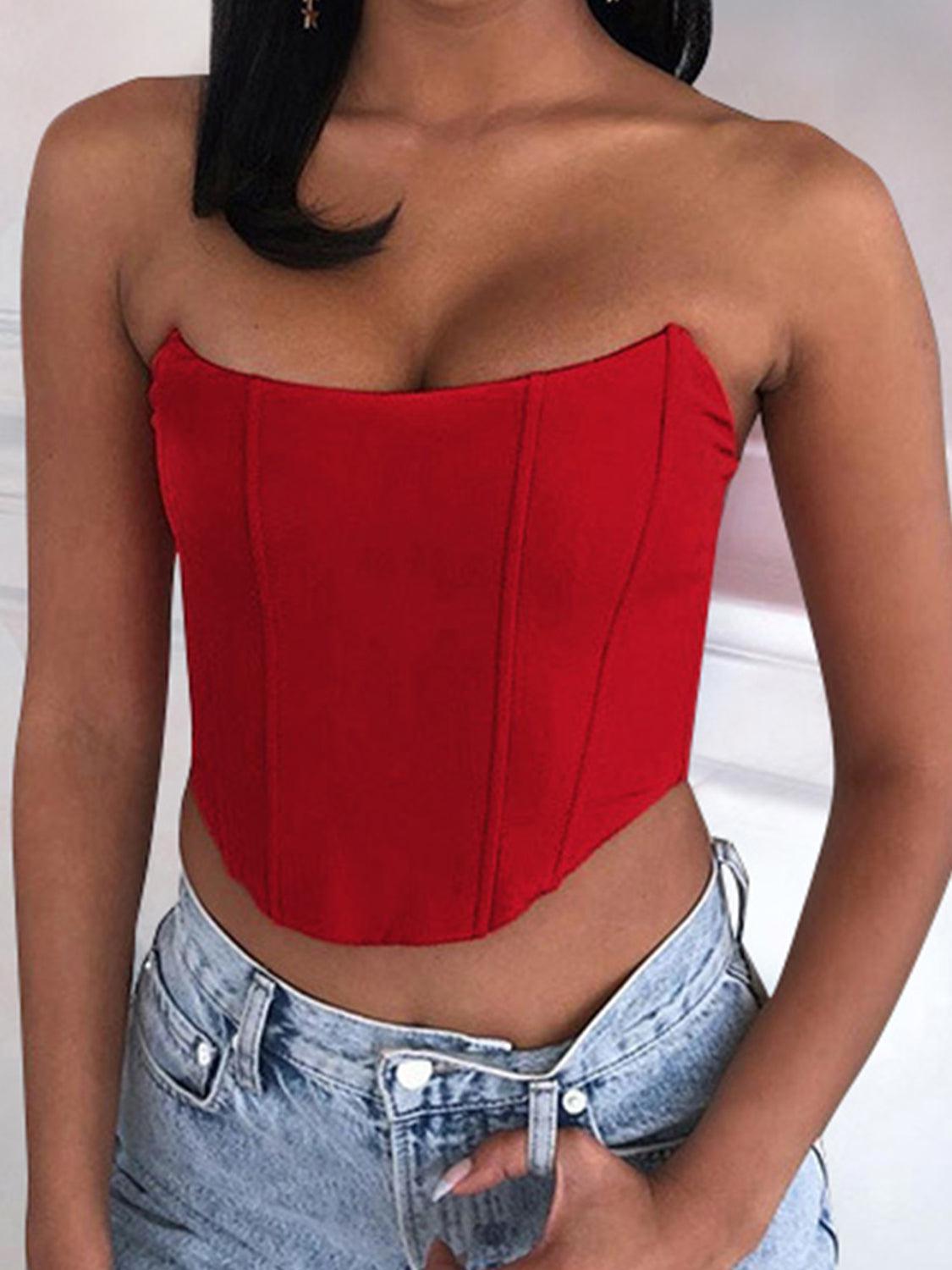 a woman wearing a red top and denim shorts