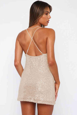 a woman wearing a gold sequin mini dress