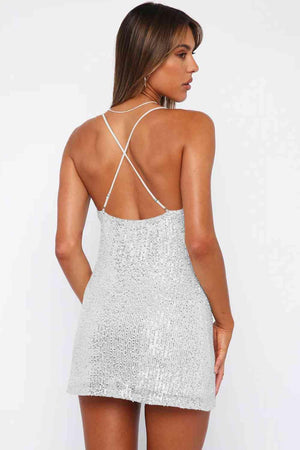 a woman wearing a silver sequin mini dress