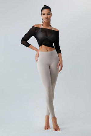 a woman in a black top and beige pants