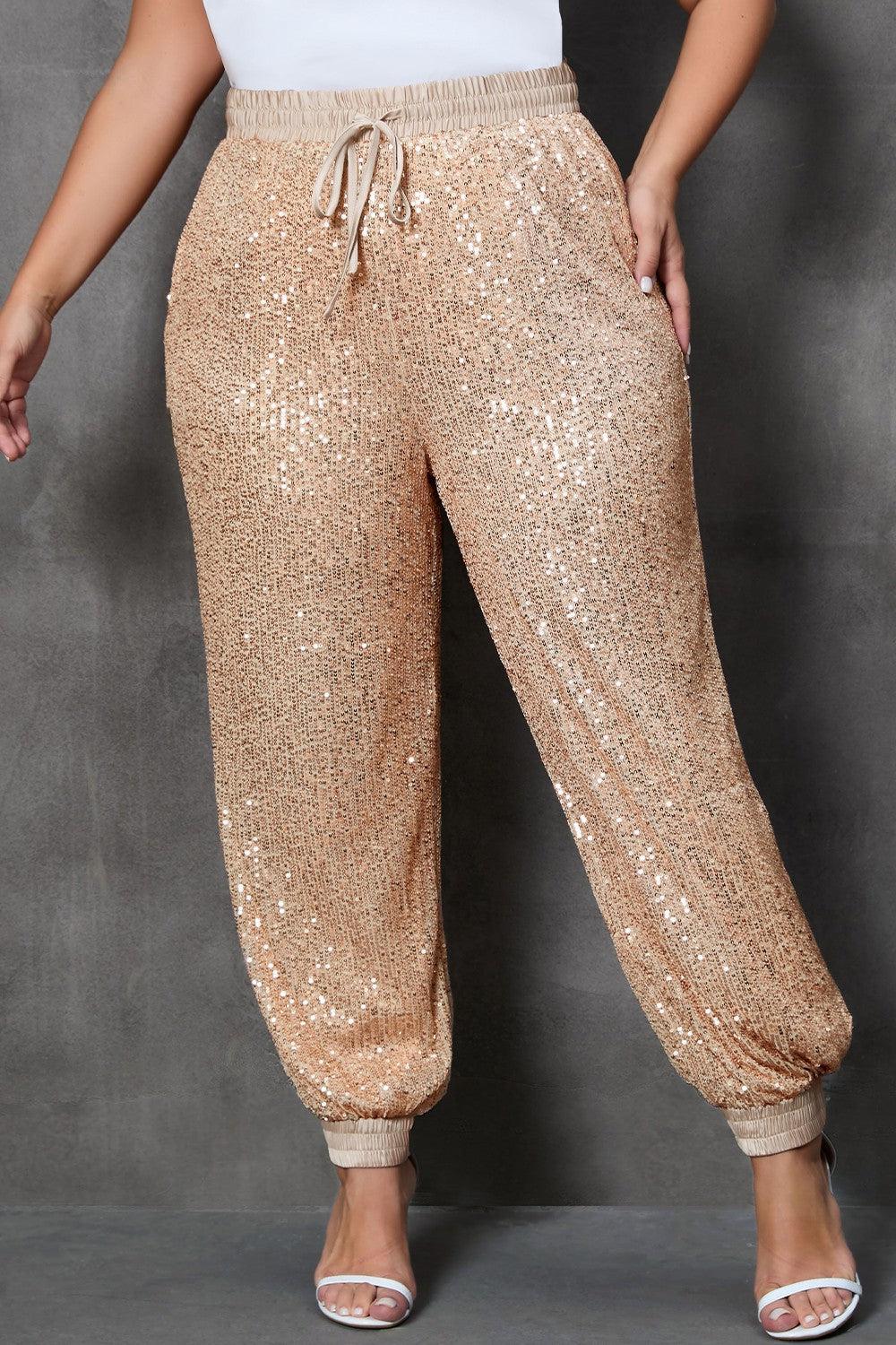 a woman in a white top and gold sequin pants