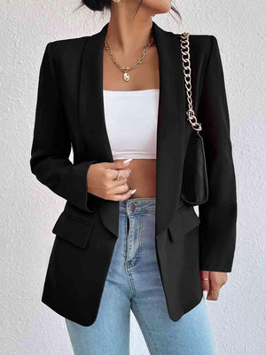 a woman wearing a black blazer and jeans