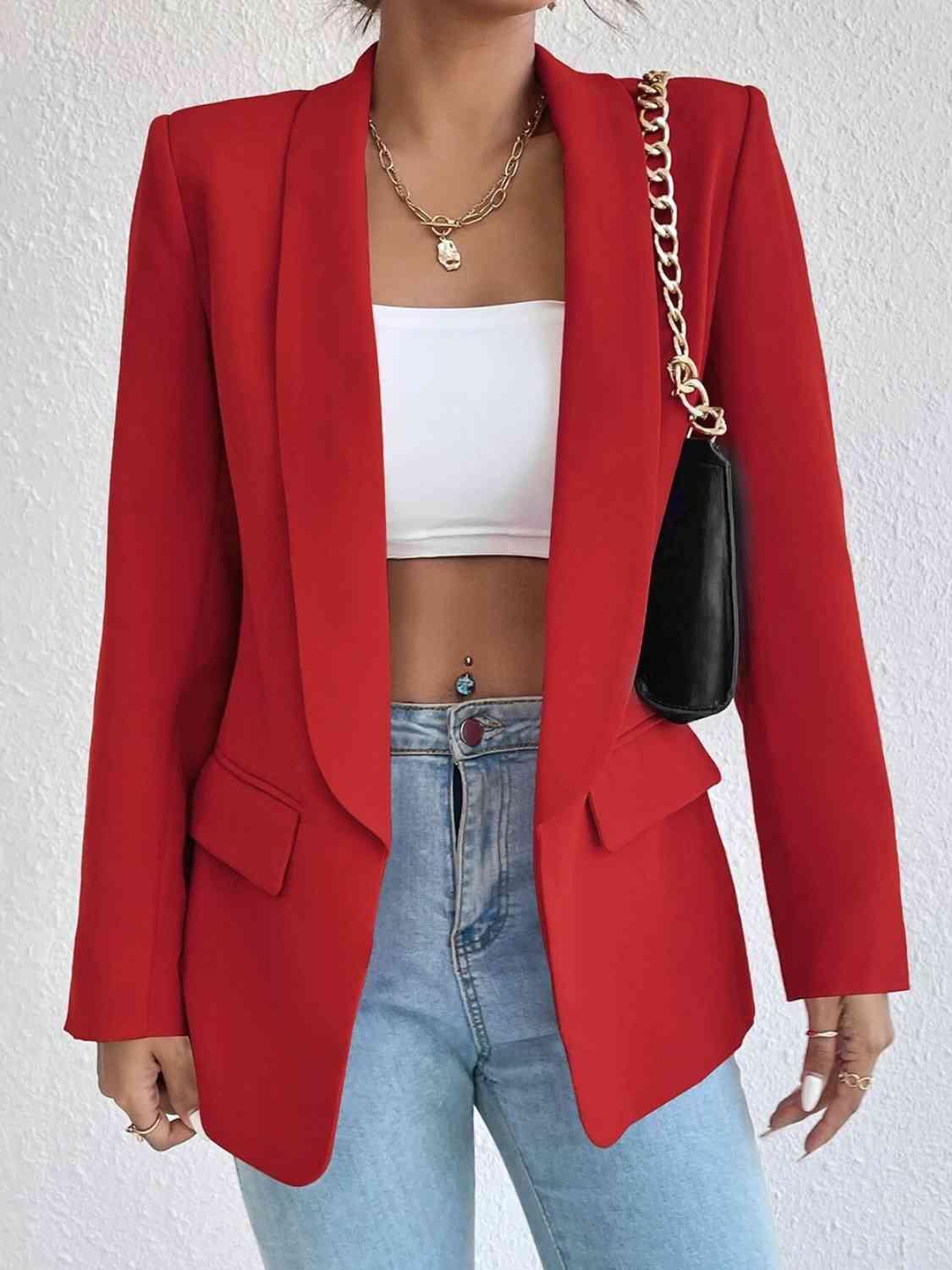 a woman wearing a red blazer and jeans