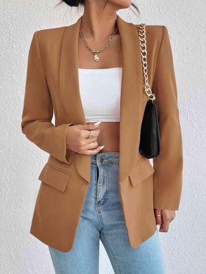 a woman wearing a tan blazer and jeans