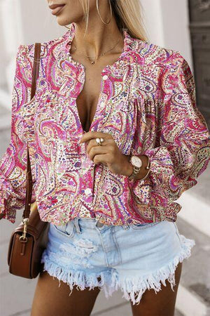 a woman wearing a pink blouse and denim shorts