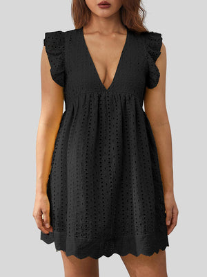 a woman wearing a black dress with a cut out back